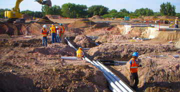 View of workers installing custom electrical work underground.