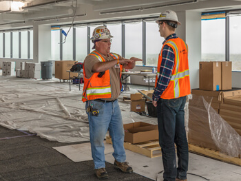 Two men discussing an electrical construction project